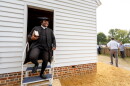Joe Feaster, a part-time historical interpreter who portrays pastor Gowan Pamphlet, steps out of the reconstructed African Baptist Meeting House, now known as First Baptist Church of Williamsburg, during a rededication ceremony in Williamsburg, Va., Friday, Oct. 9, 2026.