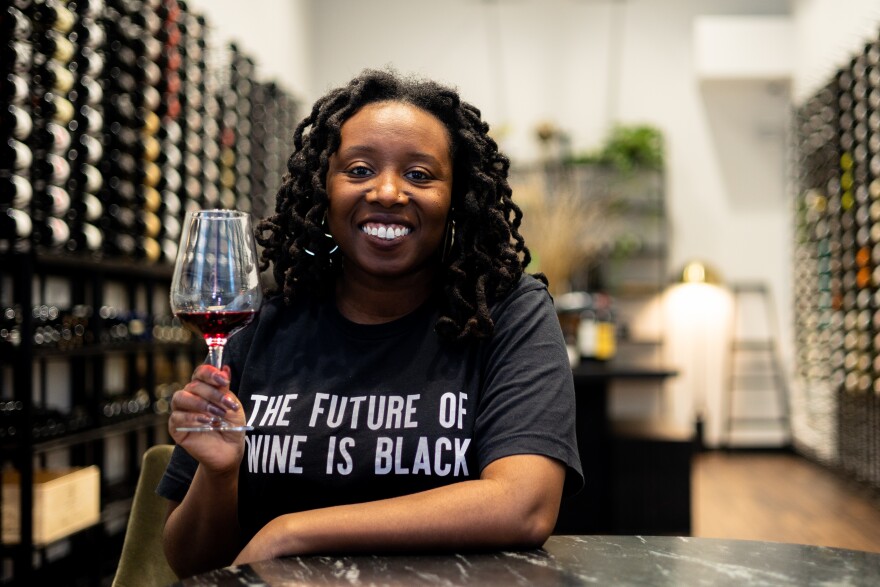 Cha McCoy, owner of The Communion Wine + Spirits, poses for a portrait in the wine gallery of her shop. Forbes has regarded McCoy as a “international woman in wine.” Her goals with the shop is to break down barriers and lift up communities underrepresented in the wine industry. She emphasized that her selection is focused on intentional wine making, which includes not only picking products from underrepresented countries, but establishments within those that are owned by it’s citizens, not by outside entities. (Isaiah Vazquez/WAER)