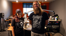 Picture of two people standing in front of a radio studio.