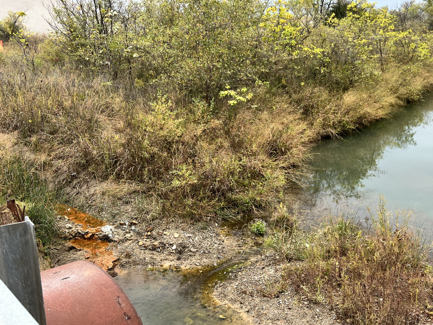 A rust-colored stream of polluted water (left) joins Tar Creek north of Miami.