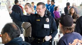 Former Juneau Chief of Police Bryce Johnson waves at a community barbecue it hosted in Marine Park to “be counted as a person against violence, against discrimination, and against hate” on July 20, 2016. (Annie Bartholomew/KTOO)