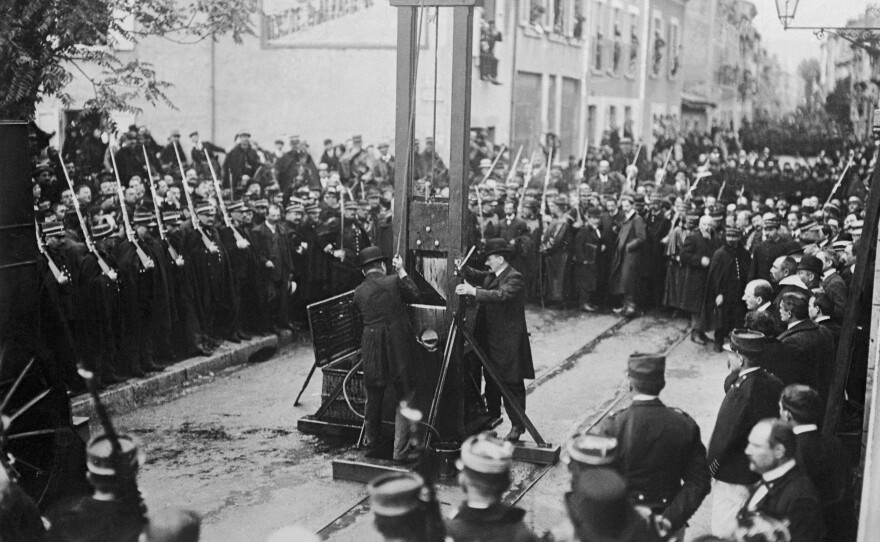 A photo dated 1929 of an execution by guillotine somewhere in France.