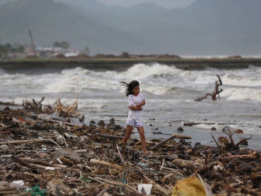 A girl walks along the shore as strong waves from Typhoon Hagupit hit Atimonan, Quezon province, eastern Philippines on Saturday.