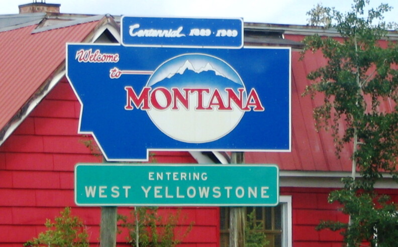 A blue sign with mountains on it reads, "welcome to Montana."