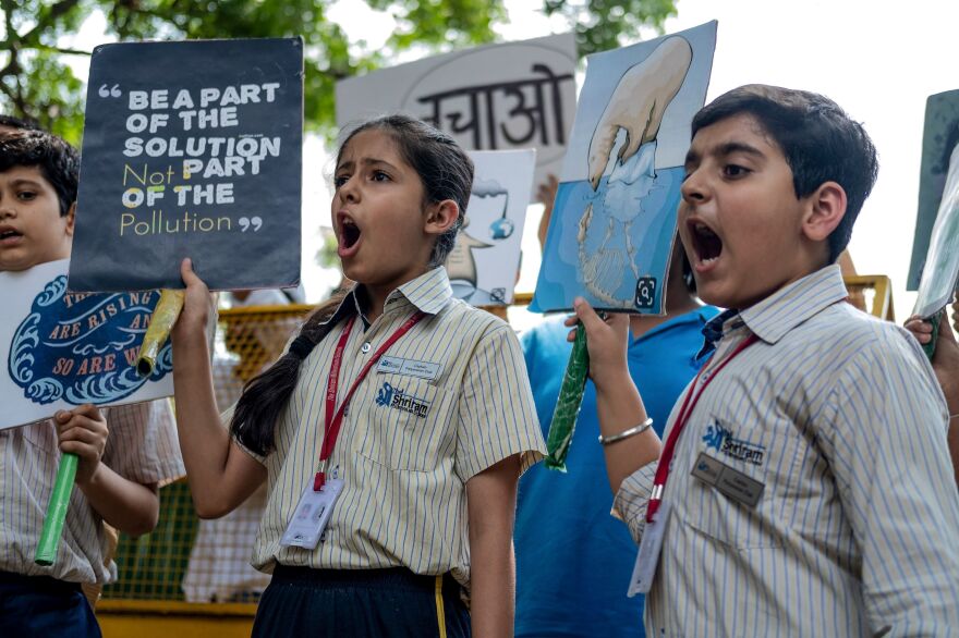 Children shout slogans as they participate in a climate strike in New Delhi.