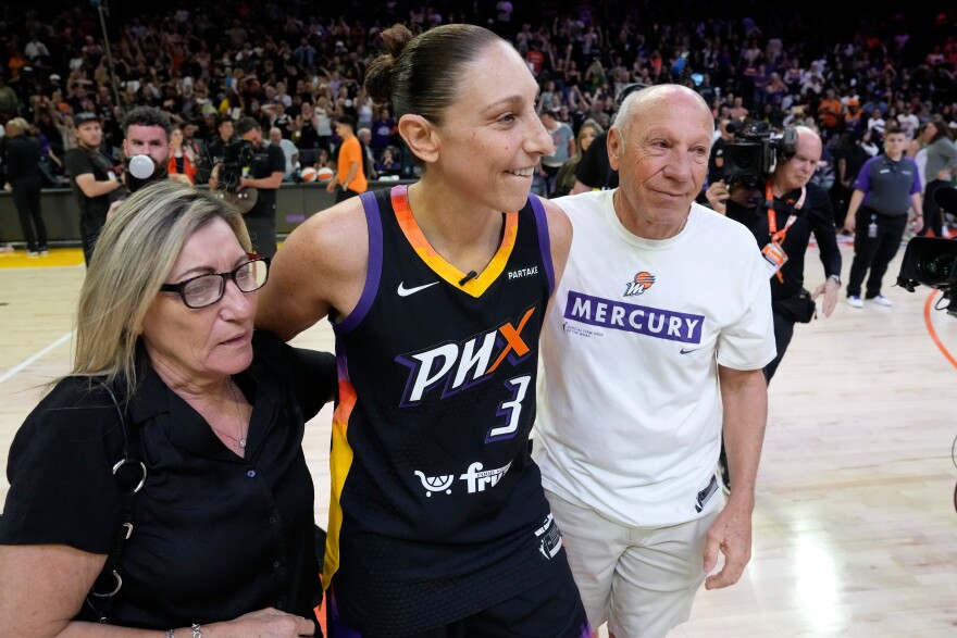 Phoenix Mercury guard Diana Taurasi, center, walks with her parents Liliana, left, and Mario, right, after a WNBA basketball game against the Seattle Storm Thursday, Sept. 19, 2024, in Phoenix.