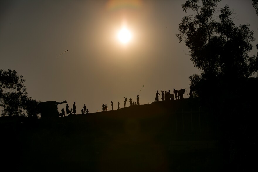 Children fly kites along a ridge in the camp. Many of the refugees fled Myanmar with only a few possessions. For some kids homemade kites are the only toys they have.