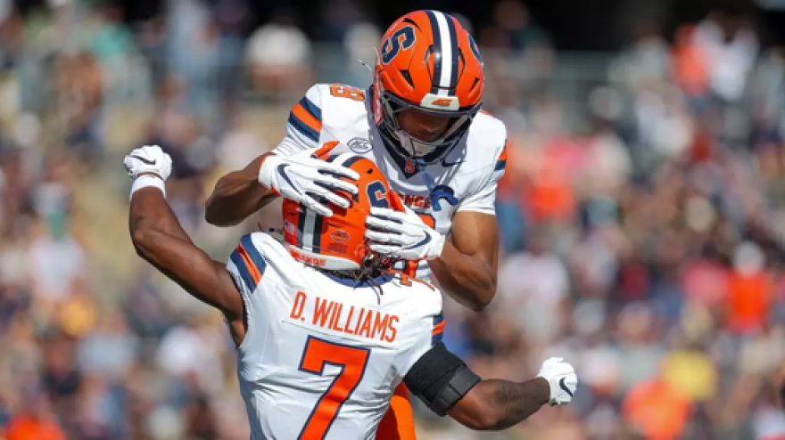 Tight end Daunte Bacheyie (19, White) jumps onto wide receiver Darien Williams (7, White).