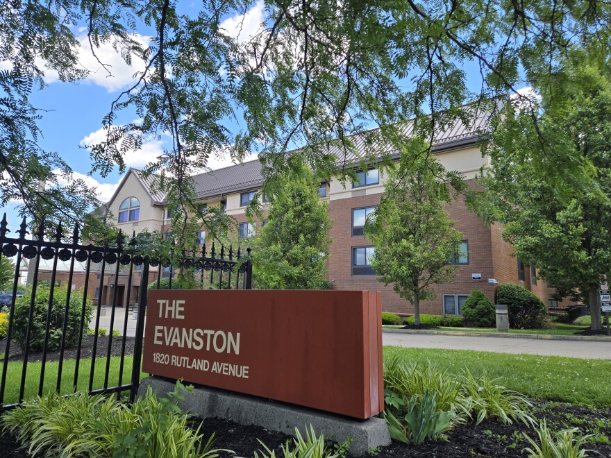 A large apartment building behind a sign reading "The Evanston."