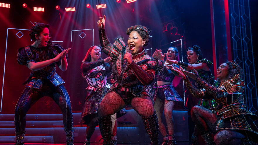 Performers from six the musical sing on stage