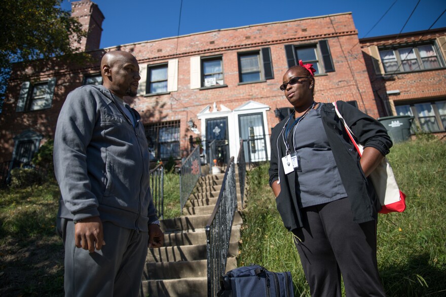 Dolman and Kelly chat outside his mother's house in Northeast Washington after the house call.