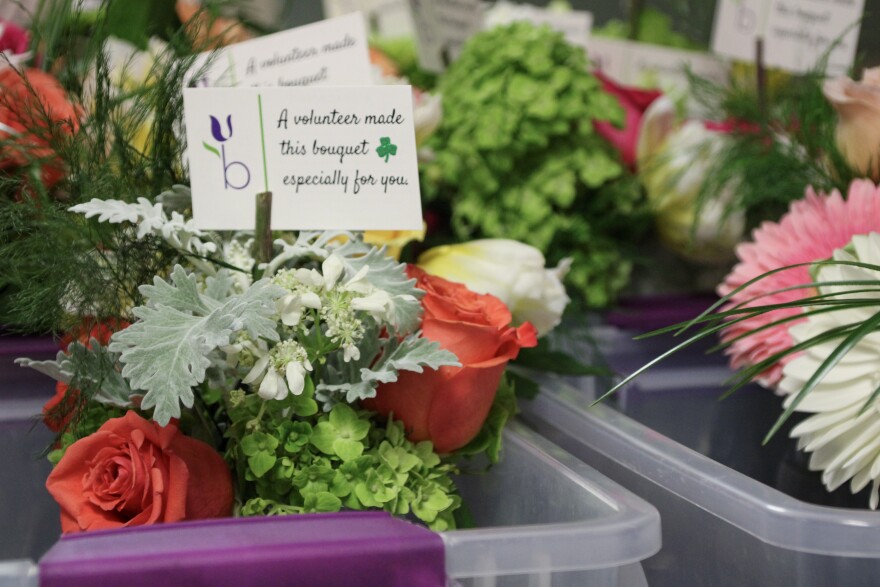 Volunteers with Unexpected Blooms break down large flower arrangements into smaller bouquets to be delivered to health care facilities around Kansas City.