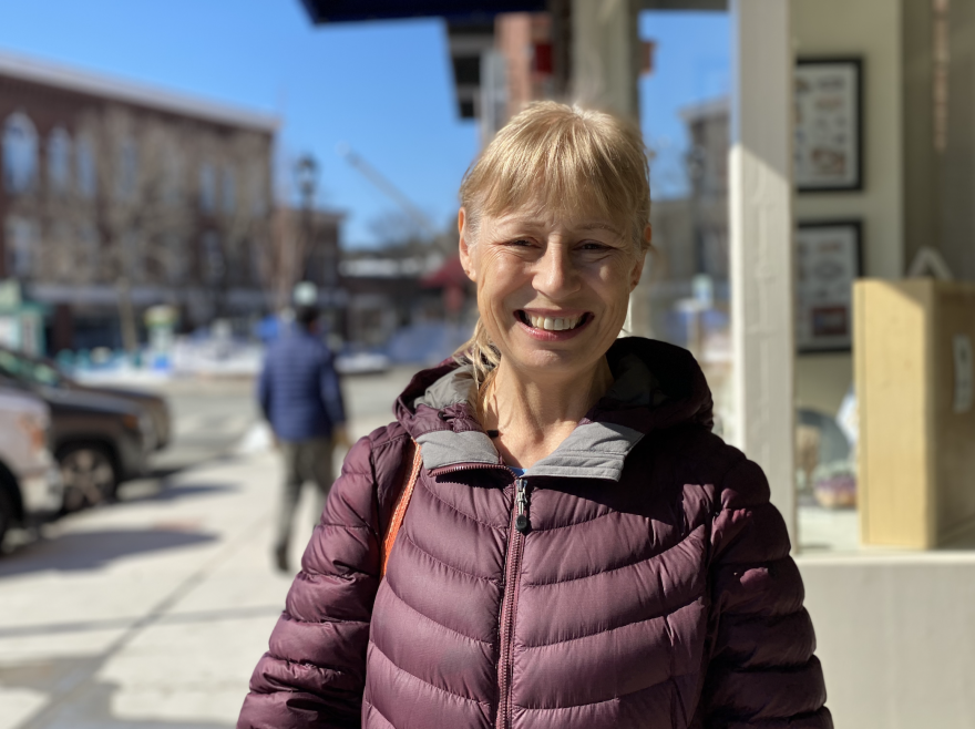 Julia Neily stands on a sidewalk and smiles at the camera