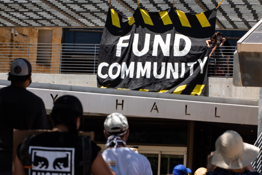 Protesters outside Austin City Hall on July 11 call for defunding the police department.