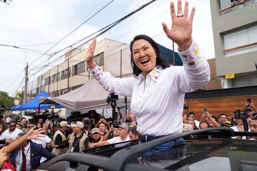 Woman waves to crowd on motorcade