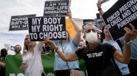 Abortion-rights activists hold signs outside the Supreme Court on Oct. 4.