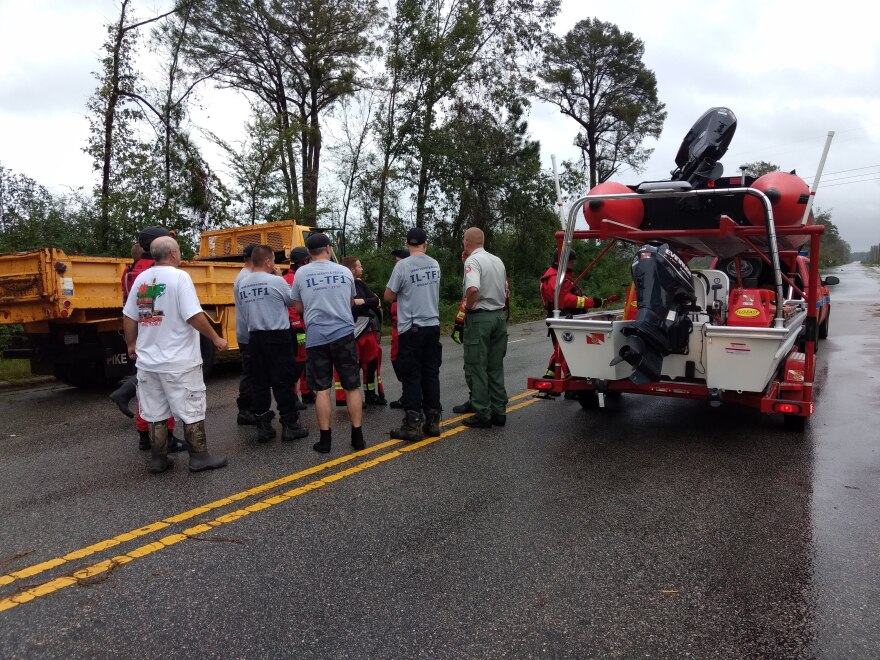 A swift water rescue team from Illinois discussed whether to chance driving across a flooded Business US 74 near Whiteville Sunday. 