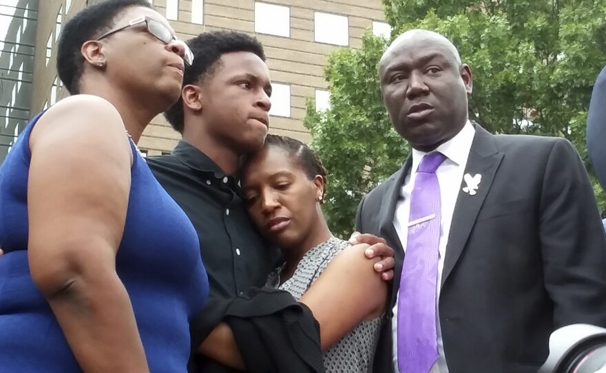 Brandt Jean, Botham Jean's brother, center left, hugs Allisa Charles-Findley at a news conference in Dallas on Sept. 10, 2018. They're joined by Jean's mother, Allison Jean, left, and attorney Benjamin Crump.