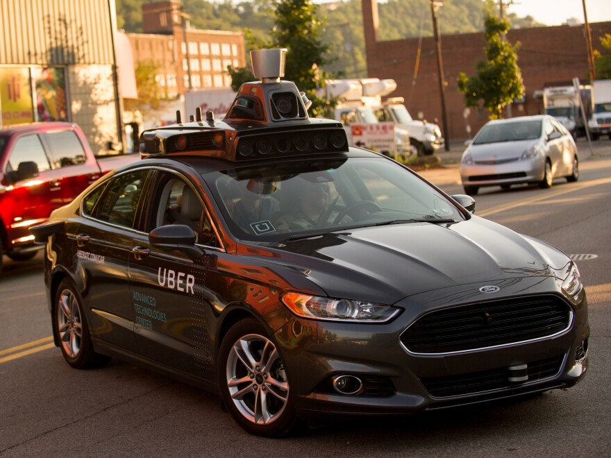 An Uber driverless Ford Fusion drives in Pittsburgh in 2016. On Friday, Uber and Google's Waymo self-driving unit announced a settlement in their trade secrets case.