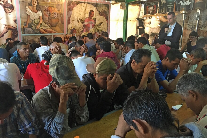 Men pray inside one of the soup kitchens for recently deported migrants in Nogales, Mexico. (Valeria Fernandez for Here & Now)
