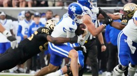 Vanderbilt defensive lineman Khordae Sydnor (96) tackles Kentucky quarterback Cutter Boley (8) during the first half of an NCAA college football game Saturday, Nov. 22, 2025, in Nashville, Tenn. (AP Photo/George Walker IV)