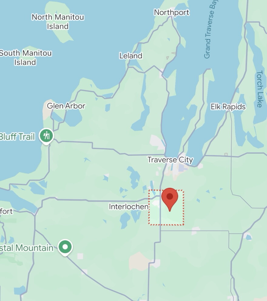 A map shows a pin dropped within a red box near Interlochen and Traverse City.
