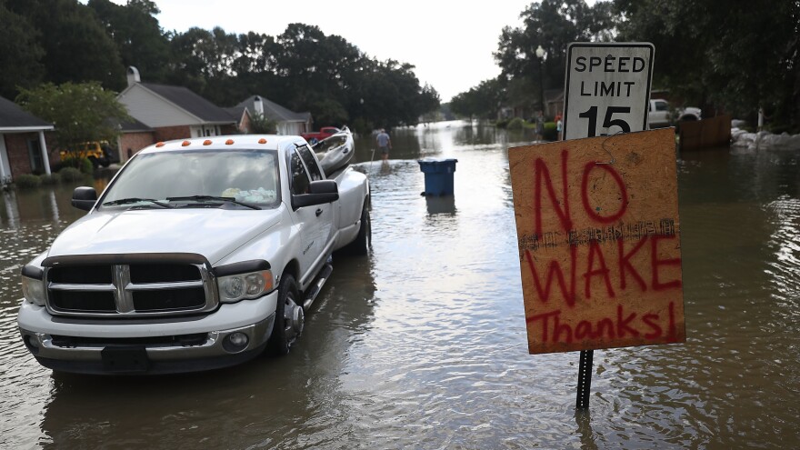 A "no wake" sign is seen along side a street in a residential neighborhood inundated with floodwaters this week in Sorrento, La.