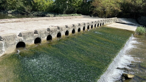 Water flows through a low-head dam.