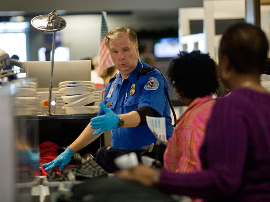 A TSA officer screens airline passengers at the Dallas/Fort Worth International Airport on Sunday. Preflight screenings were stepped up after a man was accused of trying to blow up a Northwest Airlines flight Friday.