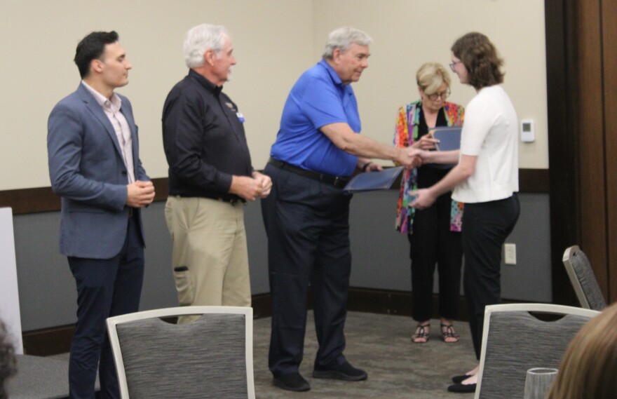Graduate Elise Gechter shakes hands with Hurst Mayor Henry Wilson before receiving her certificate from the program.
