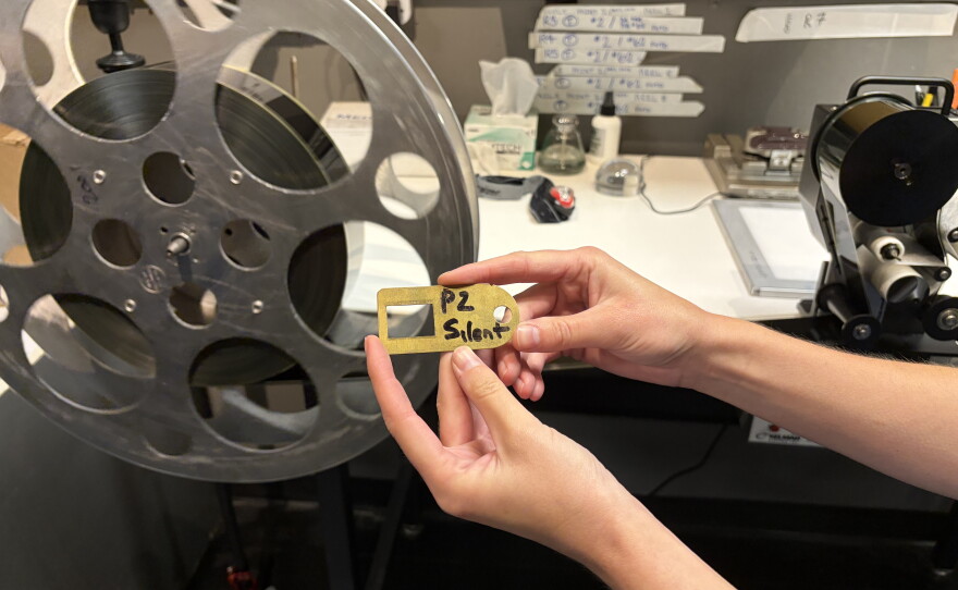 The metal object is a film gate The film gate is the rectangular opening in the front of a motion picture camera where the film is exposed to light, or the rectangular opening in the front of a film projector allowing a beam of light through when projecting the film.