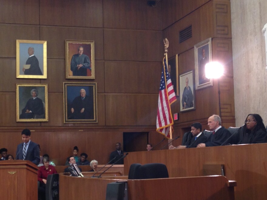 Law clerk Zayn Siddique, at the lectern, argues as the lawyer for Tinker, before Judges Sri Srinavasan, David Tatel and Ketanji Jackson.