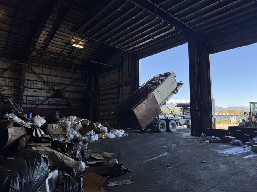 A dump truck unloads trash at the city's baling facility.
