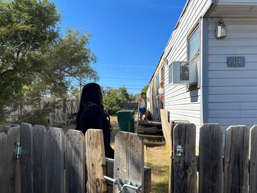 Janeth Vasquez talks with a potential voter outside her home.