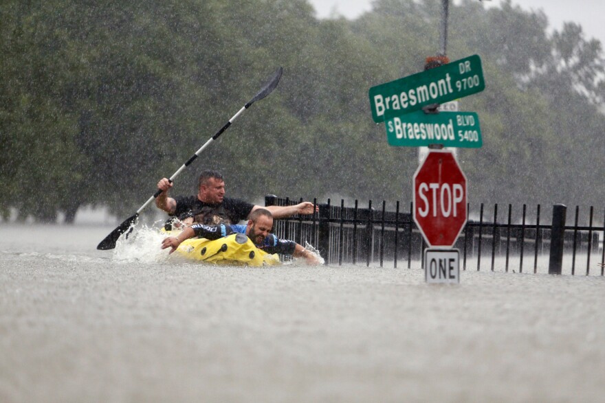 Two kayakers try to beat the current pushing them down an overflowing Brays Bayou along S. Braeswood in Houston, on Sunday. Rescuers answered hundreds of calls for help Sunday as floodwaters from the remnants of Hurricane Harvey climbed high enough to begin filling second-story homes, and authorities urged stranded families to seek refuge on their rooftops