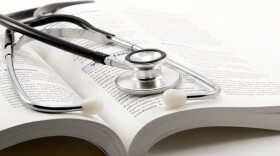 stethoscope on open book on a white background (Photo credit Dr. Farouk, CC BY 2.0, via Wikimedia Commons)