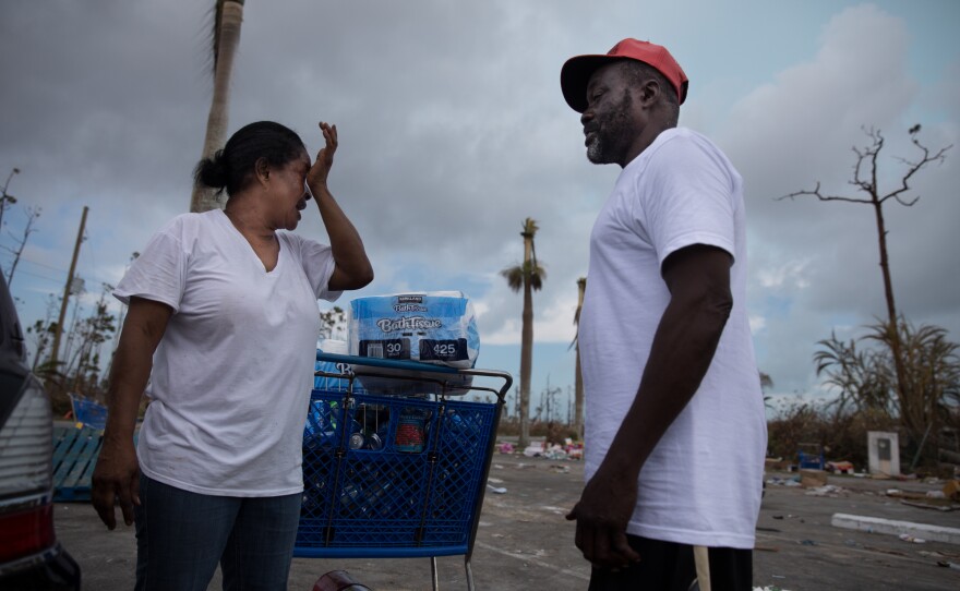 Judy Roker chats with friend John Battles Tate after stocking up on basic provisions, like water, toilet paper and canned goods from Abaco Groceries in Marsh Harbour.