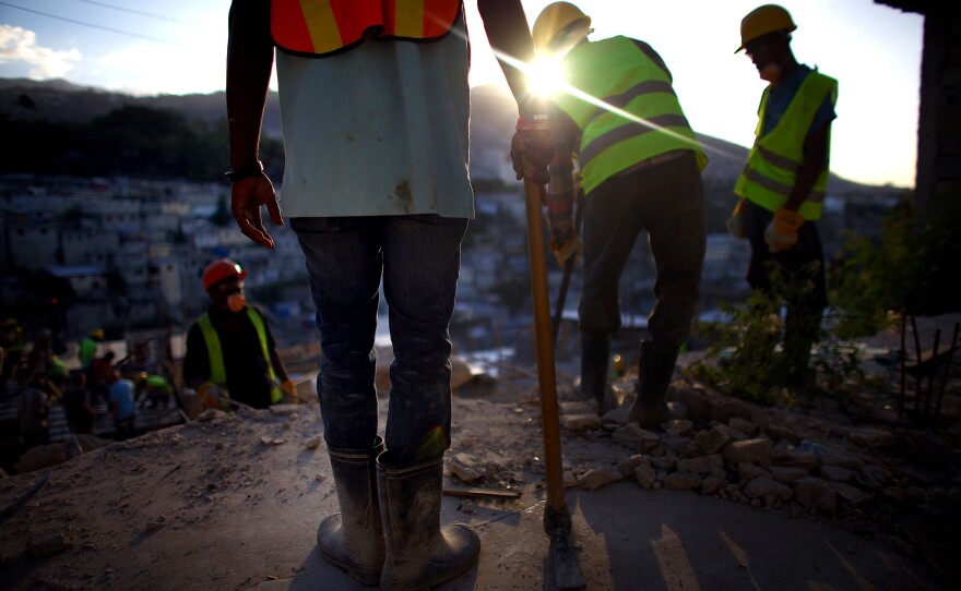 Construction workers overlook the hills above Port-au-Prince near Petionville, where an 18-unit complex is slated to go up this year. Despite billions of dollars in international donations for earthquake relief, only about 5,000 permanent houses have been built.