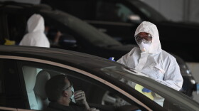 A medical worker talks to a man going through the testing process at Connecticut's first COVID-19 rapid testing center in New Haven back in April.