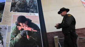 A U.S. Border Patrol agent walks past photos of slain fellow agent Brian Terry, a Marine Corps veteran, during a memorial service on Jan. 21, 2011, in Tucson. Terry was killed during a Dec. 14 shootout near the U.S.-Mexico border. Thousands of Border Patrol agents and law enforcement officers from across Arizona turned out for the memorial.