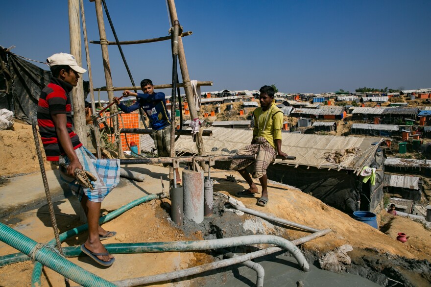 Two men operate what's called a "donkey pump" as they drill a new water well in the Balukhali refugee camp. Aid groups are providing funds and materials to dig deeper wells that are less likely to get contaminated during seasonal flooding.