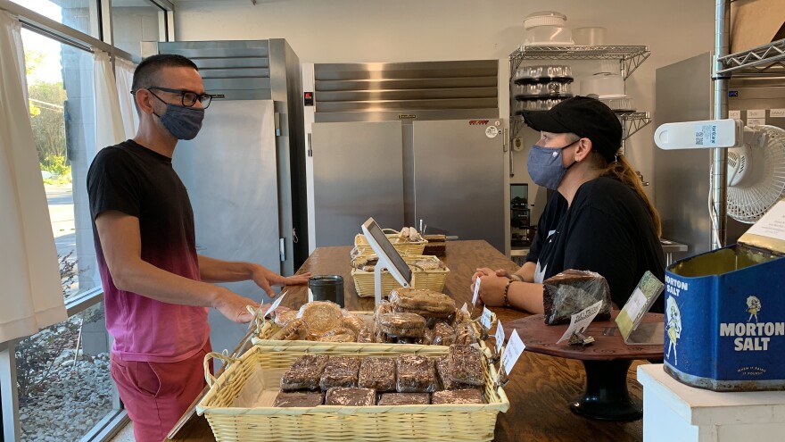 Jennifer Derby, right, the front end customer service specialist for BakerBaker, speaks with a new customer, left, about which baked goods to get. (Abigail Hasebroock/WUFT News)