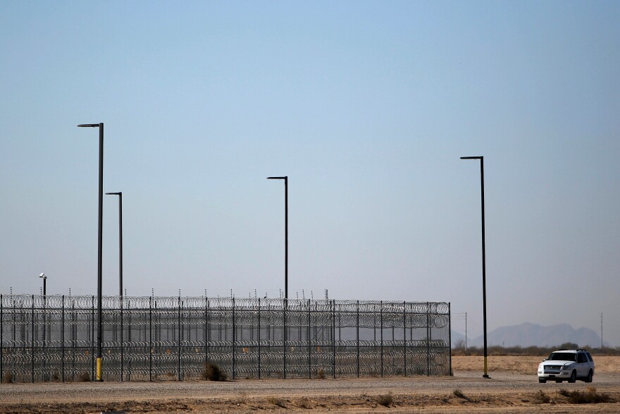 FILE - In this 2016 file photo, an unmarked police truck patrols the outside of the Saguaro Correctional Center private detention center operated by CoreCivic in Eloy, Ariz.