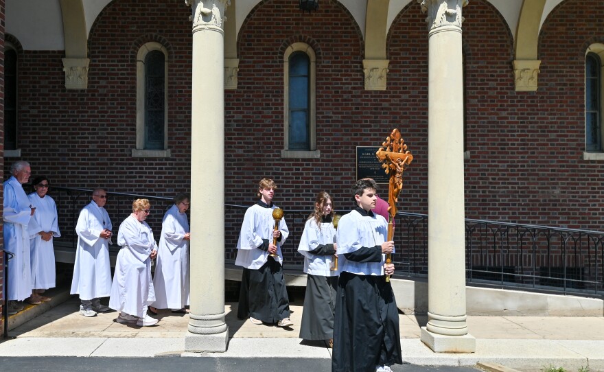 Tommy Killino leads the procession followed by Ronnie and Katie Kucharski during the Novena.