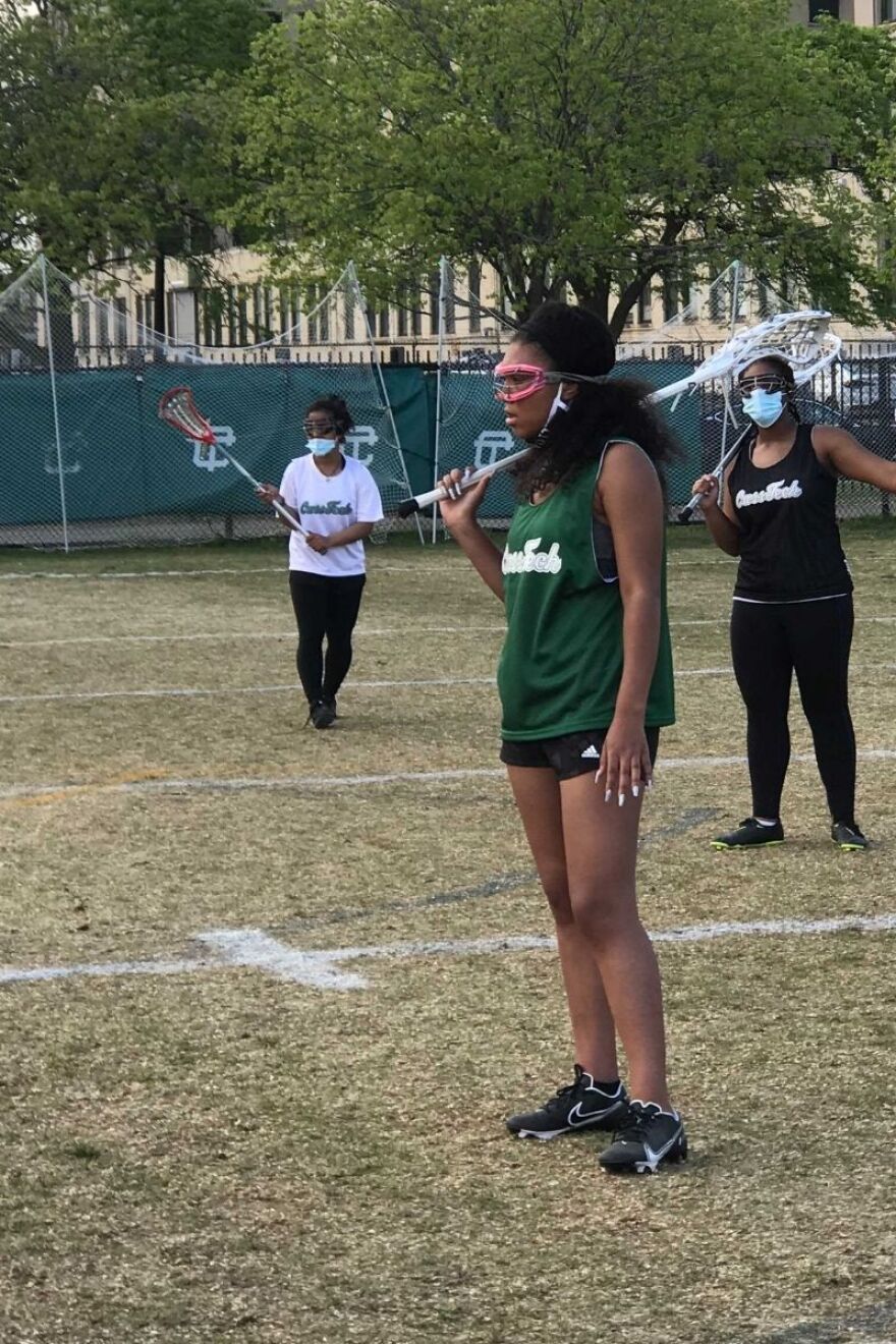 Deja crenshaw stands with lacrosse stick over her right shoulder