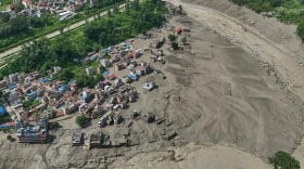 Damaged houses stand precariously near the swollen, debris-choked banks of the Trishuli River after flash floods in Nepal's Nuwakot district on Wednesday, Aug. 26, 2026. (Niranjan Shrestha/AP)