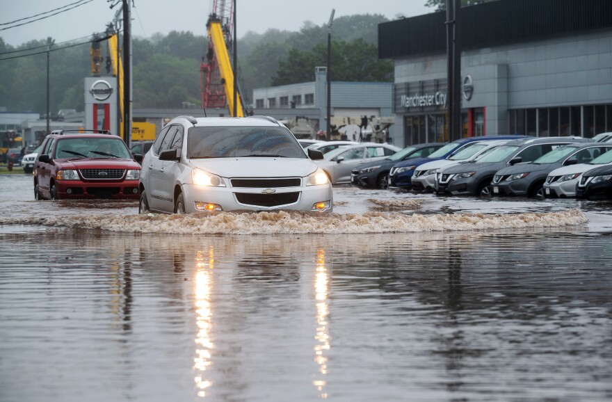 Manchester, CT - August 22, 2021: Cars drive through a portion of Route 83 in Manchester that was flooded by tropical storm Henri. (Tyler Russell/Connecticut Public)