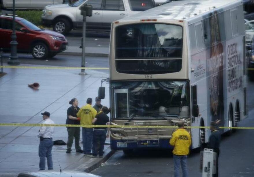 Las Vegas police investigate the scene of a stand-off in a bus along Las Vegas Boulevard, Saturday, March 25, 2017, in Las Vegas. Las Vegas police said the gunman in a fatal shooting on the Strip who barricaded himself inside a public bus has surrendered peacefully after shutting down the busy tourism corridor for hours.