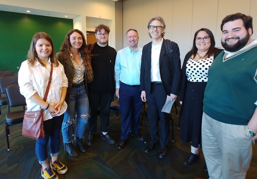 Student interns and two men pose for photo