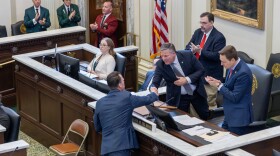 enate Pro Tem Lonnie Paxton shakes hands with Gov. Kevin Stitt on the House floor during the 2025 State of the State Address.